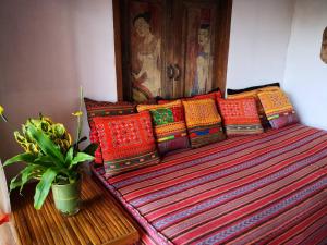 um banco com almofadas coloridas no quarto em Phu Chaisai Mountain Resort em Mae Salong Nai