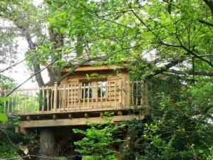 una casa en el árbol sentada en la parte superior de un puente en Domaine de la Boere, en Beaulieu-sous-la-Roche
