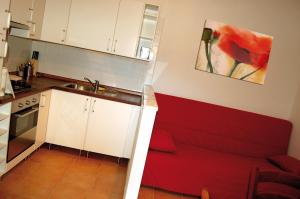 Villa FaraldiAgriturismo LE GOCCE的一间带红色沙发的小厨房 更多5张照片