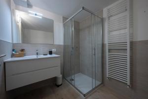 ein Bad mit einer Glasdusche und einem Waschbecken in der Unterkunft Appartamento S. Croce in Levico Terme