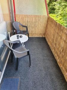 a small patio with two chairs and a table at Vier Jahreszeiten, Appartment 723, Hahnenklee - Bockswiese in Goslar