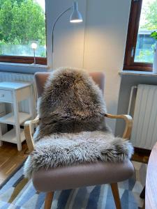 a brown chair with a furry pillow on it at Guesthouse Jensen Aarhus in Risskov
