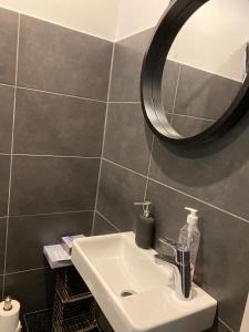 La salle de bains est pourvue d'un lavabo et d'un miroir. dans l'établissement Guesthouse Jensen Aarhus, à Risskov