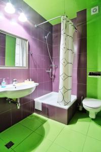 a bathroom with a sink and a tub and a toilet at Rosa Del Viento Hotel in Tuapse