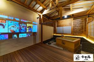 Großes Zimmer mit Badewanne und TV. in der Unterkunft Konjaku-So Shinsaibashi Rooftop SPA in Osaka