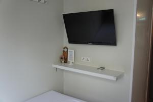 a bathroom with a tv on a white wall at Ocean Inn in Hong Kong