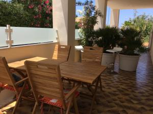 einen Holztisch und Stühle in einem Zimmer mit Pflanzen in der Unterkunft La Villa BIANCA in Ragusa