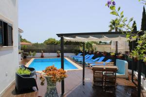 um pátio com cadeiras e uma piscina em Villa Quinta do Algarve em Albufeira