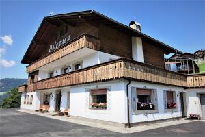 a building with a wooden roof and windows at Pension Dolomieu in Santa Cristina Gherdëina