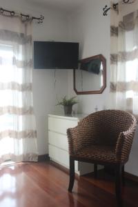 FamalicãoにあるCasa da Cilinhaの椅子、鏡、ドレッサーが備わる客室です。