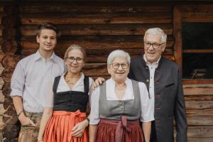 a family posing for a picture in front of a cabin at Hotel Kreuz in Pfunds