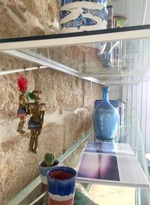 a glass shelf with some vases andartifacts on it at Calida B&B in Castellammare del Golfo