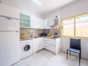 una cucina bianca con lavatrice e lavatrice di LA ALCAZABA - Exclusive Penthouse a Málaga
