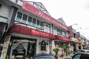 a building with cars parked in front of it at Rose Cottage Hotel Taman Daya in Johor Bahru