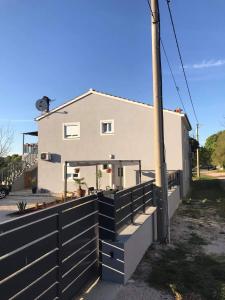 ein Haus mit einem Zaun davor in der Unterkunft Apartmani Đokić in Bale
