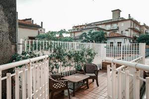 balkon z krzesłami, stołem i ogrodzeniem w obiekcie Angelica Home w Mestre