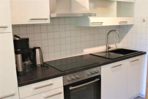 a white kitchen with a sink and a stove at FeWo an der Mühle in Bad Bentheim