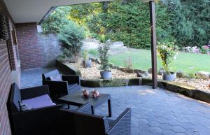 a patio with a table and chairs and a garden at FeWo an der Mühle in Bad Bentheim