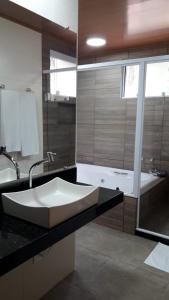 a bathroom with a large sink and a tub at Pousada Recanto da Serra in São Pedro da Serra