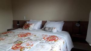 Un dormitorio con una cama grande con flores. en Pousada Recanto da Serra, en São Pedro da Serra