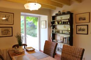 a dining room with a table and chairs and a book shelf at Les Chenevières in Culey