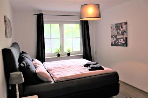 a bedroom with a bed in front of a window at FeWo an der Mühle in Bad Bentheim