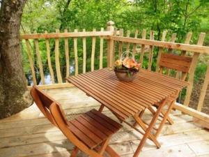 a wooden table and two chairs on a wooden deck at Domaine de la Boere in Beaulieu-sous-la-Roche