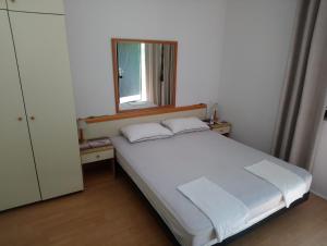 1 dormitorio con cama blanca y ventana en apartmani ANITA, Korčula, en Korčula