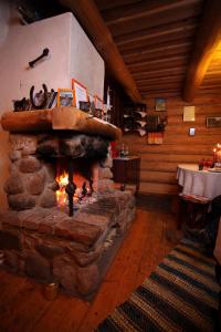a stone fireplace in a room with a table at Zirgu sēta "Klajumi" - Horse ranch "Klajumi" in Kaplava