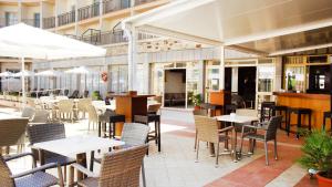 un restaurante con mesas y sillas en un edificio en Hotel Iris, en El Arenal