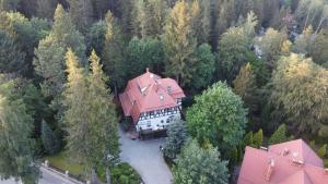 eine Luftansicht eines großen Hauses inmitten eines Waldes in der Unterkunft Mon Plaisir in Karpacz