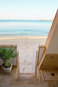 a stairway leading to the beach with a potted plant at White Bay in Fontane Bianche