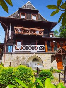 ein großes Holzhaus mit Balkon in der Unterkunft Willa Silesia in Wisła