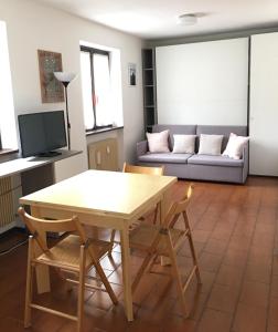 a living room with a table and chairs and a couch at Grazioso monolocale a pochi passi dal centro cittadino in Chiesa in Valmalenco