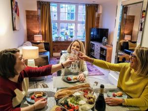 three women sitting around a table drinking wine at Cocoa River - Quiet city centre, close to the Shambles, on the river, two bed, two bath, allocated parking in York