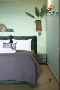 een slaapkamer met een bed en een plant aan de muur bij Crystal View - Elsa's Apartments in Kavala