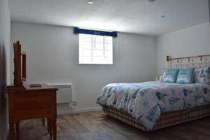 1 dormitorio con 1 cama, vestidor y ventana en Plain Street Cottage, The Barn B&B, en Port Isaac