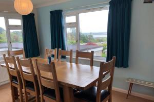 a dining room table with chairs and a large window at Nyth Y Wiwer, Spacious and Peaceful Bungalow Near Harlech in Llanfair