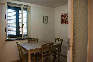 comedor con mesa, sillas y ventana en Finisterrae, en Procida