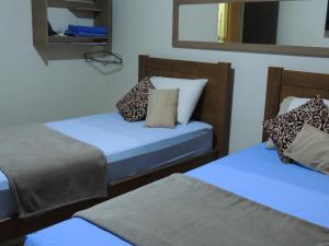 Tempat tidur dalam kamar di Quartos Em Casa Caxias - Pousada Paraíso