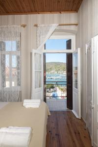 Schlafzimmer mit einem Bett und einem Fenster mit Aussicht in der Unterkunft Neoclassical manor house in Poros