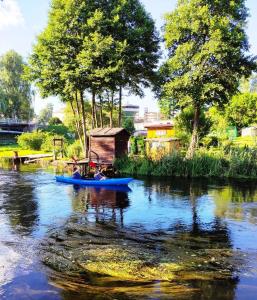 a blue boat on a river with a shack at Poddasze in Zblewo