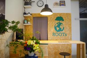 um quarto com uma mesa e um sinal que lê raízes em Travelers' house ROOTs em Takaoka