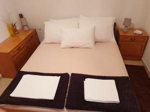 a bed with two white pillows and two white sheets at Ana in Kostrena