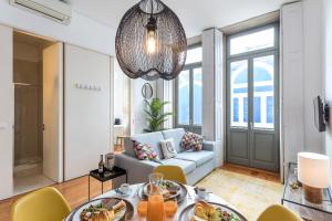a living room with a couch and a table with food at Apartamentos Villa Bolhao in Porto