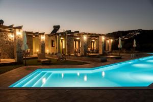 a swimming pool in front of a house at night at ONAR in Palekastron