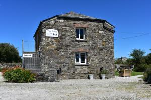 an old stone building with signs on it at Plain Street Cottage, The Barn B&B in Port Isaac