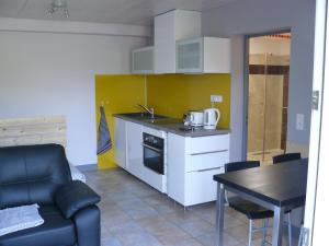 a kitchen with a table and a couch and a kitchen with a stove at STUDIO ENTRE SAVINES ET EMBRUN PRES DU LAC DE SERREPONçON in Crots