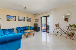 een woonkamer met blauwe banken en een fiets bij Kotor Sunset Apartments in Kotor