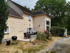 una casa con una griglia di fronte di Les Coucous ad Augerville-la-Rivière